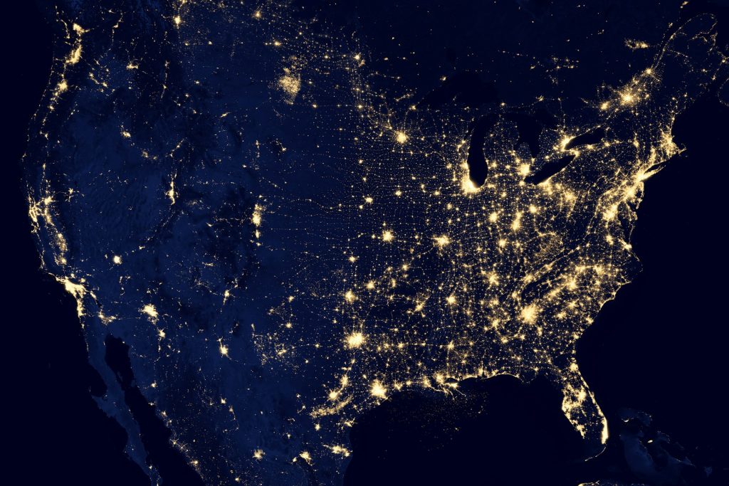 Aerial map of the United States at night showing concentrations of light at large cities.